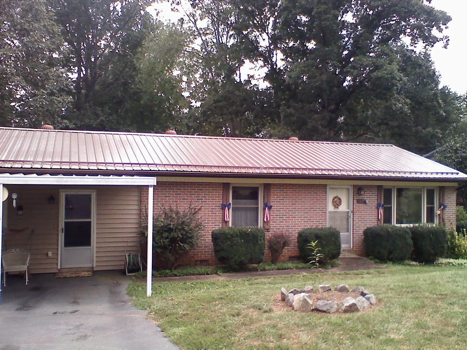 Bronze metal roof and carport on a brick ranch home — Roof Repair work by our crew in Monterey